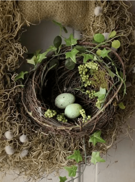 a burlap wreath with a grapevine nest, faux greenery and green eggs is a gorgeous Easter decoration for your front door and not only