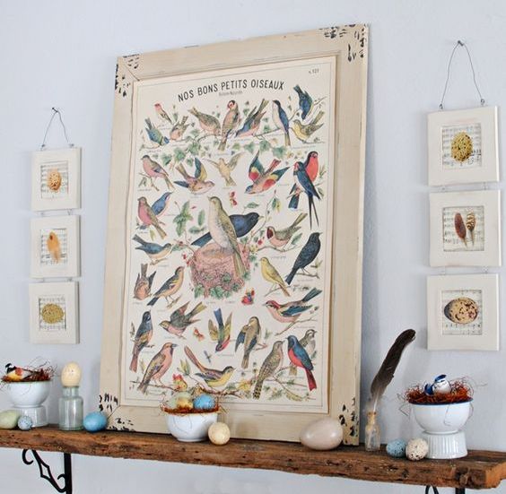 a colorful Easter mantel with vintage bird and egg posters, fake eggs and nests and feathers