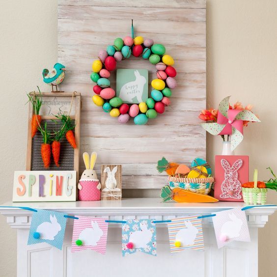 a colorful and fun Easter mantel with a bright egg wreath, a bunny bunting, a string art piece, some bunnies and a carrot garland