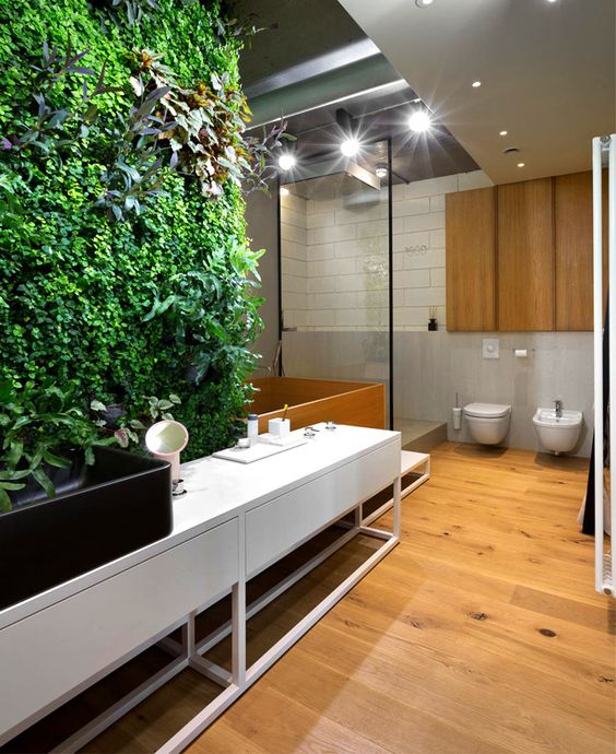a contemporary bathroom with a living wall that is a statement here, it brings freshness and color to the space