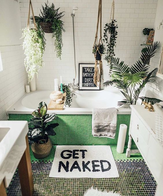 a contemporary bathroom with small tiles, lots of suspended planters with greenery and plants here and there