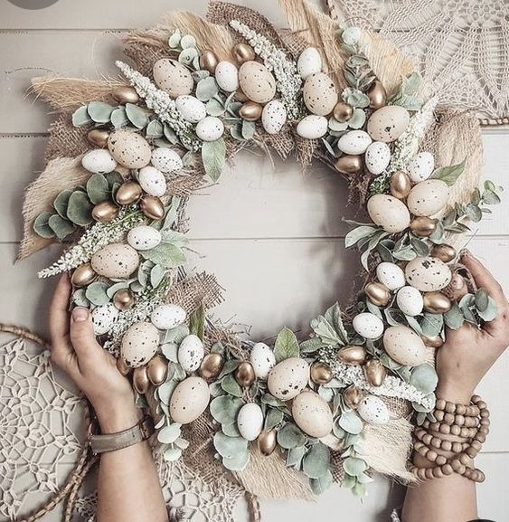 a cute rustic Easter wreath of burlap, leaves, astilbe, fake speckled adn gilded eggs is a lovely decoration
