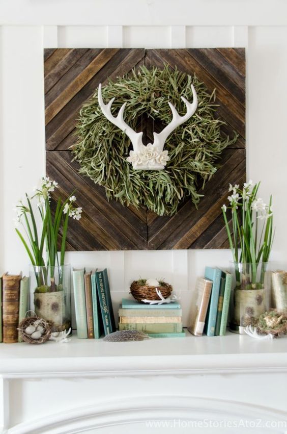 a cute spring mantel with a touch of wild, blooming bulbs, nests with fake eggs and a sign with antlers and a grass wreath