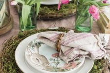 a fresh spring place setting with a vine and greenery charger, bunny printed plates, a striped napkin and tulip centerpieces
