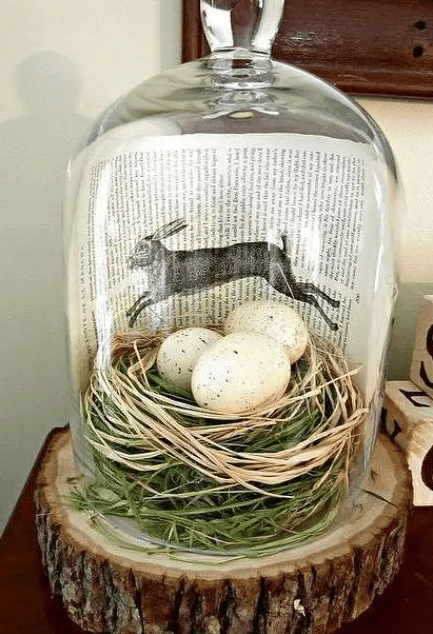 a modern terrarium with grass, hay, speckled eggs and a book page is a lovely rustic vintage Easter decoration