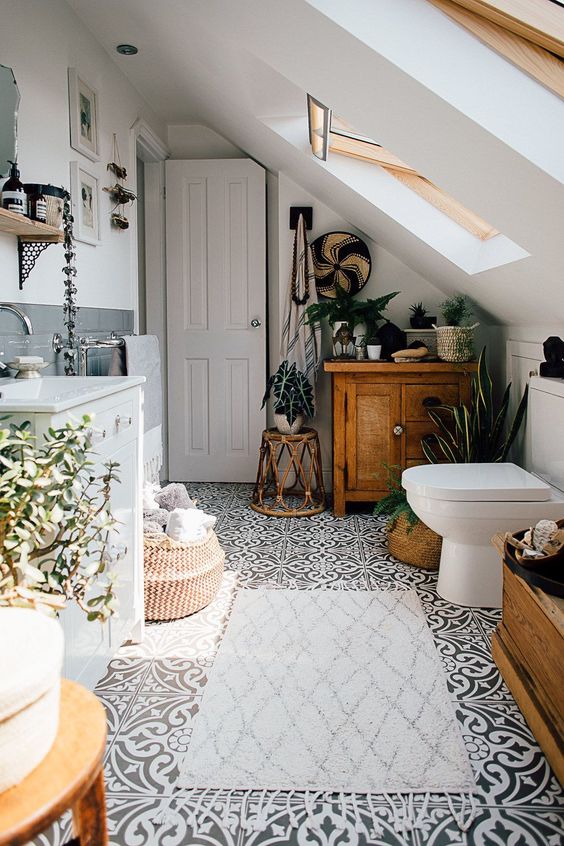 a monochromatic attic bathroom with potted greenery and succulents that add a fresh and cool feel to the space