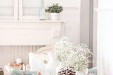 a pastel vintage-inspired tablescape with a baby’s breath centerpiece, wicker chargers, blue napkins and bunny ear napkin rings