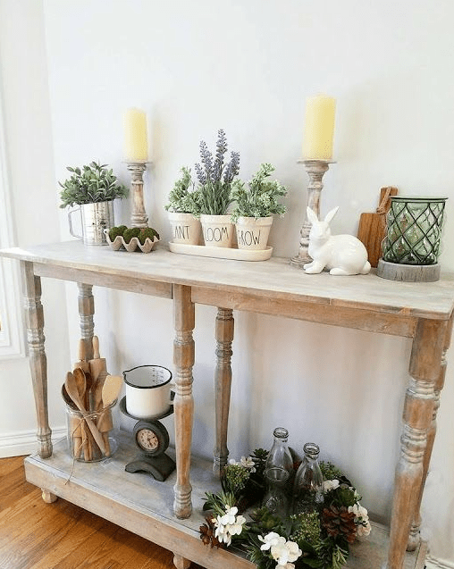 a rustic Easter console table with potted greenery and flowers, moss, candles and a porcelain bunny