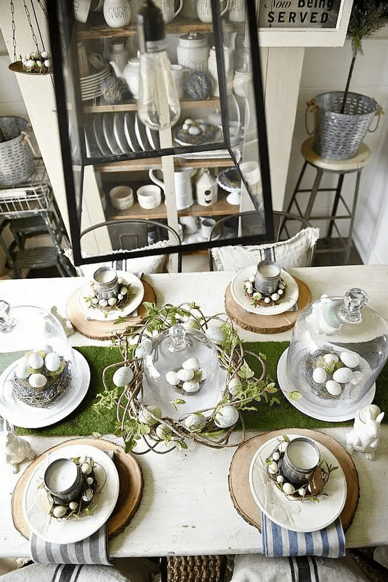 a rustic Easter table setting with wood slices, striped napkins, tin can candles, vine wreaths with eggs