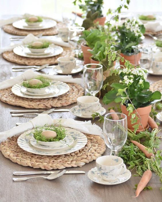 a rustic Easter tablescape with woven placemats, printed porcelain, potted blooms and greenery, nestss with eggs