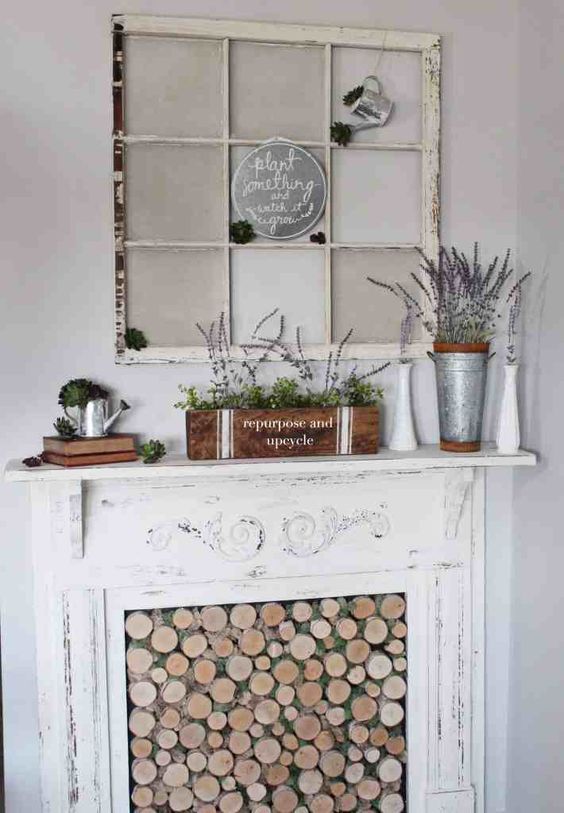 a rustic spring mantel with potted lavender, some succulents and a vintage winwod with a rustic watering can