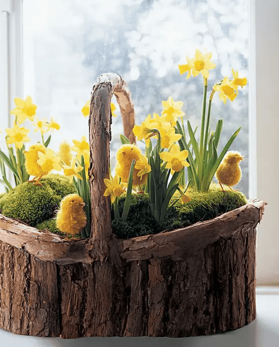 a wooden basket filled with moss, yellow daffodils and faux chicks is a fantastic rusic decoration for any space, including outdoors