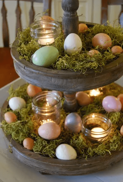 a wooden cupcake stand with moss, eggs and candles is a creative rustic Easter centerpiece or decoration to make