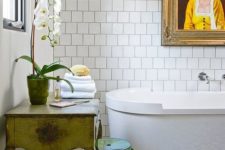 an eclectic bathroom with a colorful tile floor, a vintage vanity and an acrylic stool plus a white orchid for a refined touch