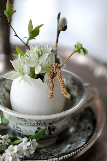 cute spring blooms and greenery placed in a large egg as an Easter arrangement