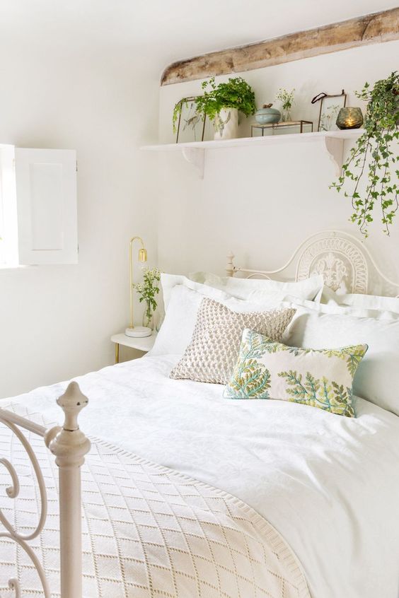 fresh greenery in pots and botanical pillows make the neutral space feel like spring and make it inviting