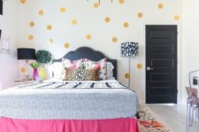 gold polka dots, a pink bed cover, some floral bedding make the space feel very spring-like