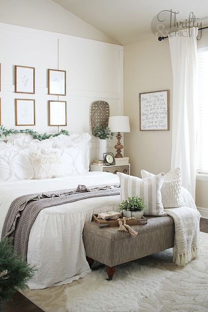 potted greenery and a faux greeneyr garland make this neutral farmhouse bedroom refreshed and spring-like