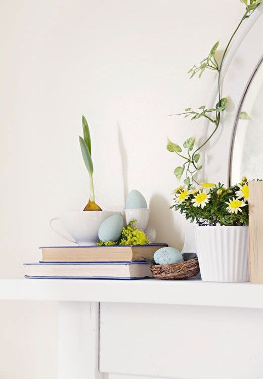 simple spring and Easter styling with potted blooms, blue eggs in a nest and a bulb in a tea cup