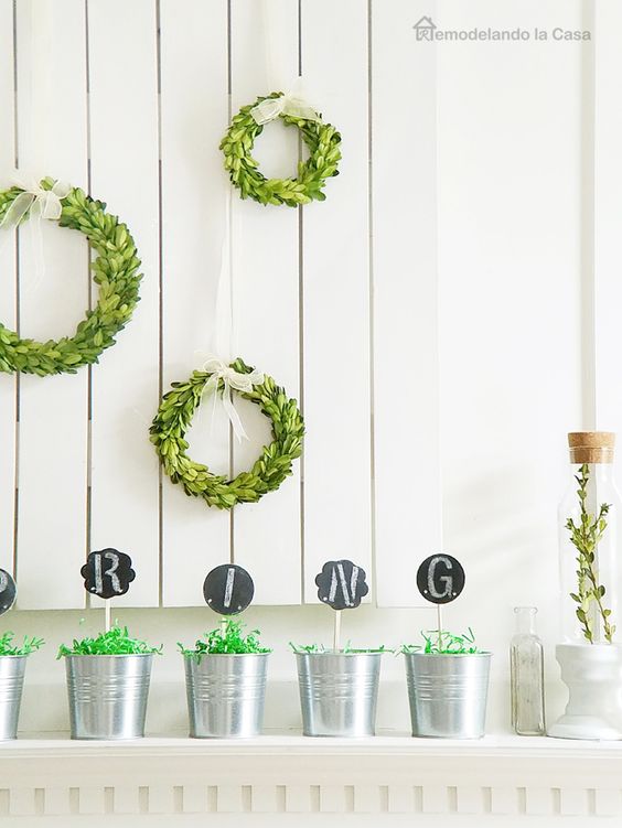 simple spring styling with little boxwood wreaths, buckets with chalkboards and greenery