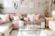 a beautiful feminine living room with dove grey walls, a corner sofa with pink and neutral blankets and pillows, lovely gold decor and a tiered coffee table