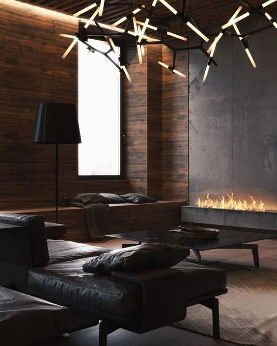 a contemporary living room with a fireplace, dark leather furniture, a stylish chandelier and a large window plus lamps
