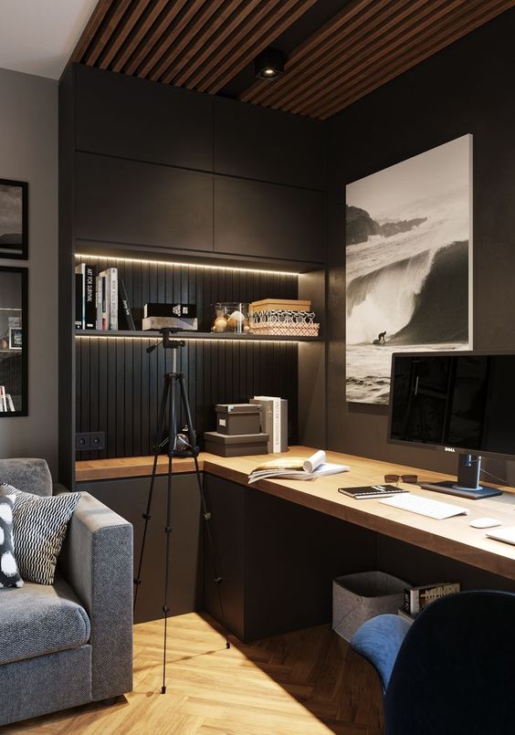 a contemporary moody home office with closed and open storage units, built-in lights, a large desk and upholstered chairs