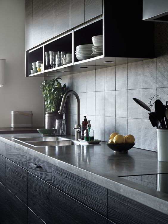 a dark and moody kitchen with dark stained furniture, stone countertops, a grey tile backsplash for a masculine feel