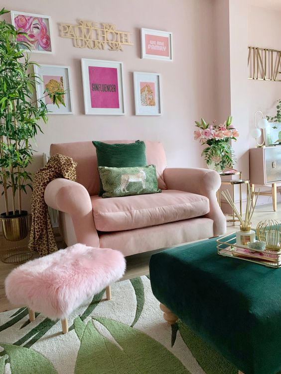 a fab living room with blush walls, a blush chair and a pink pouf, a green ottoman and a gallery wall, potted plants and blooms