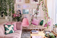a gorgeous girlish space with pink walls, a mauve sofa and a hot pink chair, a pendant floral chair with pink pillows, potted greenery and a gallery wall