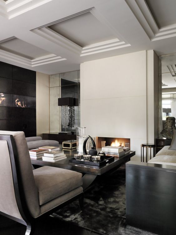 a luxurious masculine living room with white walls, grey and black furniture, a fireplace, lamps and artworks