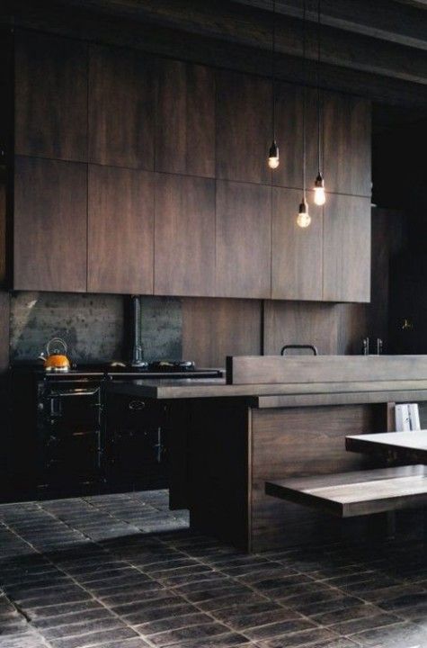 a moody wooden kitchen with pendant lamps, a metal backsplash and a hearth for more coziness