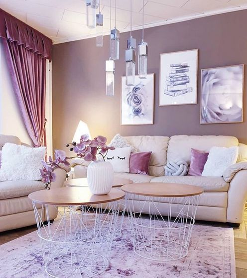 a pretty and chic girlish space with neutral seating furniture, mauve walls, purple curtains and pillows, a cluster of pendant lamps and round coffee tables