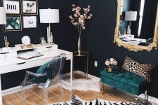 a refined working space with black walls, a white desk, an acrylic chairs, a dark green upholstered ottoman, a mirror in a gilded frame, a zebra print rug and a leopard print pillow