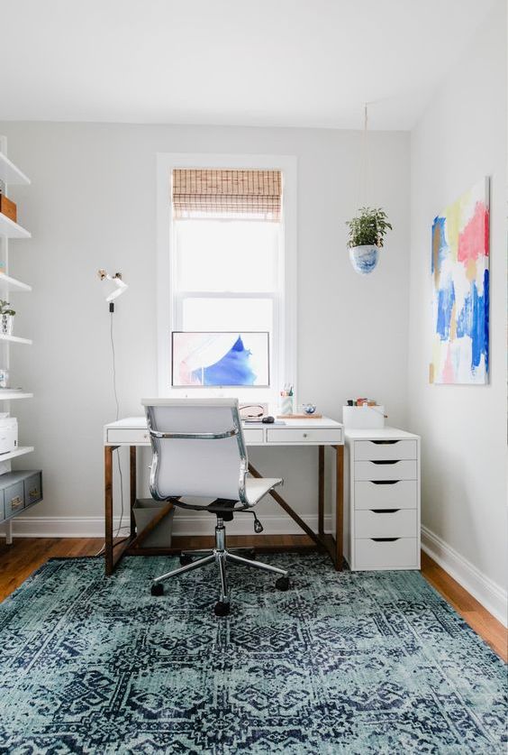 a single bright artwork and soem greenery in a pot make the home office bright and spring-inspired