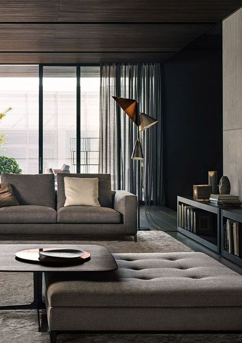 a stylish living room with neutral upholstery and a rug, floor lamps, a wooden coffee table and a storage unit