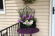 a vine wreath with colorful eggs, potted blooms and faux eggs in a planter, fake bunnies for porch decor