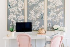 beautiful light blue flora and fauna artworks and pink chairs make the home office spring-like