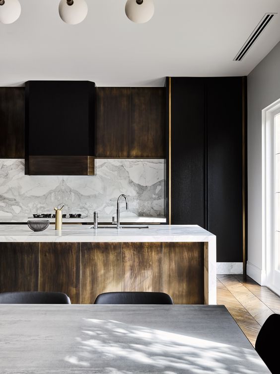 black and light-colored wooden cabinets, a marble backsplash and countertops for a chic touch