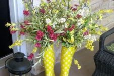 bright yellow rubber boots with a colorful floral arrangement and a candle lantern to welcome Easter