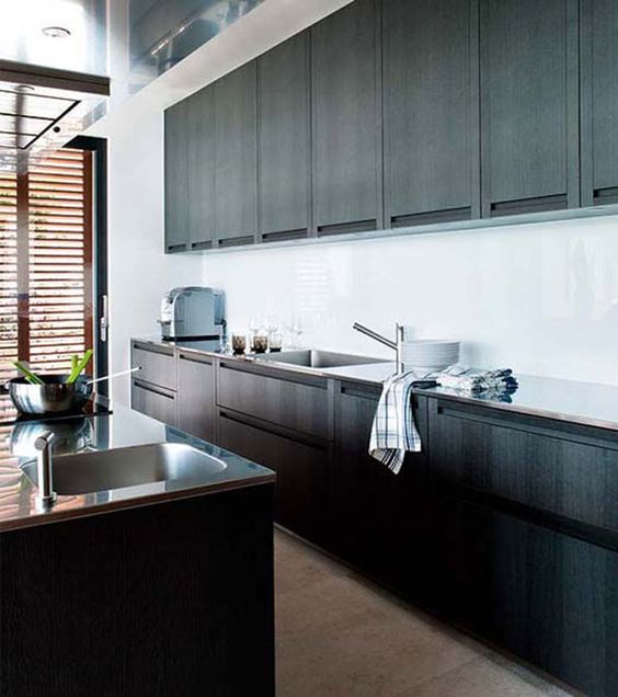 rich stained wooden cabinets, a white backsplash and metal countertops plus shutters for a private feel