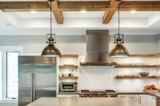 a barn kitchen with white cabinets, a wood and corrugated steel kitchen island, wooden beams, metal pendant lamps