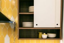 a bold and catchily shaped yellow and white tile kitchen backsplash is a colorful touch to the space