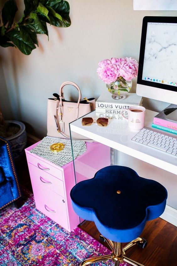 a bright and fun girlish home office with a navy stool, a hot pink cabinet, a bright printed rug and more pink touches