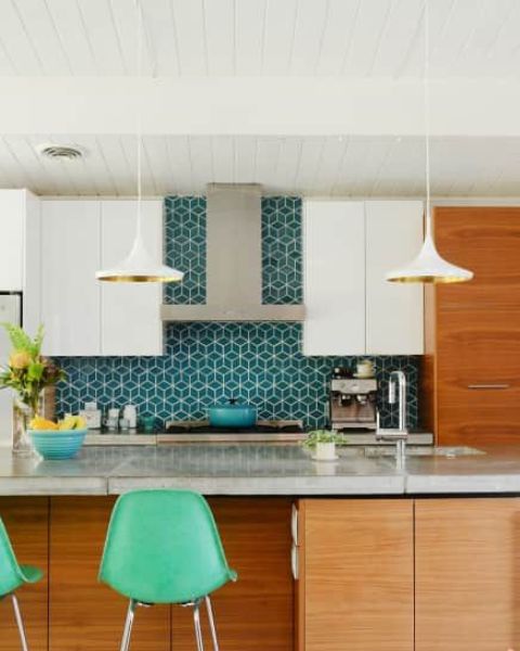 a light stained and white kitchen with sleek cabinets and a bold blue geo tile backsplash that adds interest and color to the space