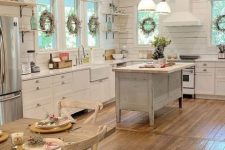 a neutral barn kitchen with planked walls, a reclaimed wood ceiling, white cabinets and a shabby chic kitchen island, pendant lamps
