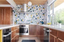 a rich-stained mid-century modern kitchen with grey, blue, white, navy and yellow tiles clad with a geometric pattern is a lovely idea