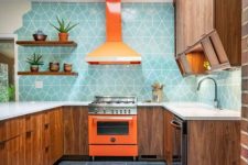 a rich-stained modern kitchen with white countertops, a bold orange cooker and a hood and a bright blue geo tile backsplash