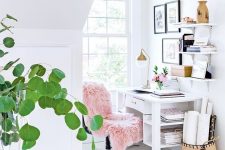 a small airy home office with a comfy desk and chair, some shelves, a basket and a gallery wall