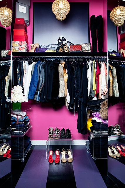 a super bold and glam closet in purple, hot pink and black, with a gold chandelier, acrylic storage shelves and an open clothes rack